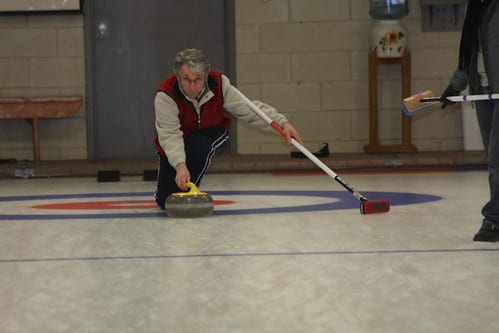 Man sliding curling rock