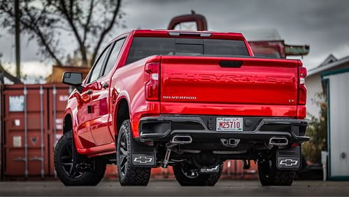 Rear of red Chevrolet Silverado HD on industrial work site with gray skies