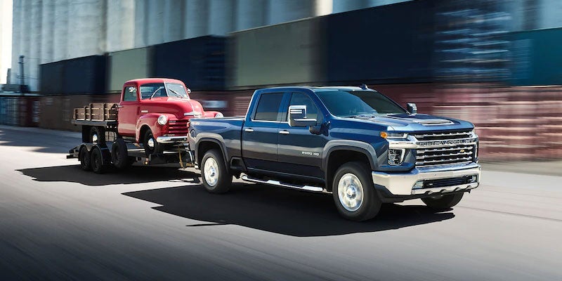 Chevy Silverado towing an older pick up truck